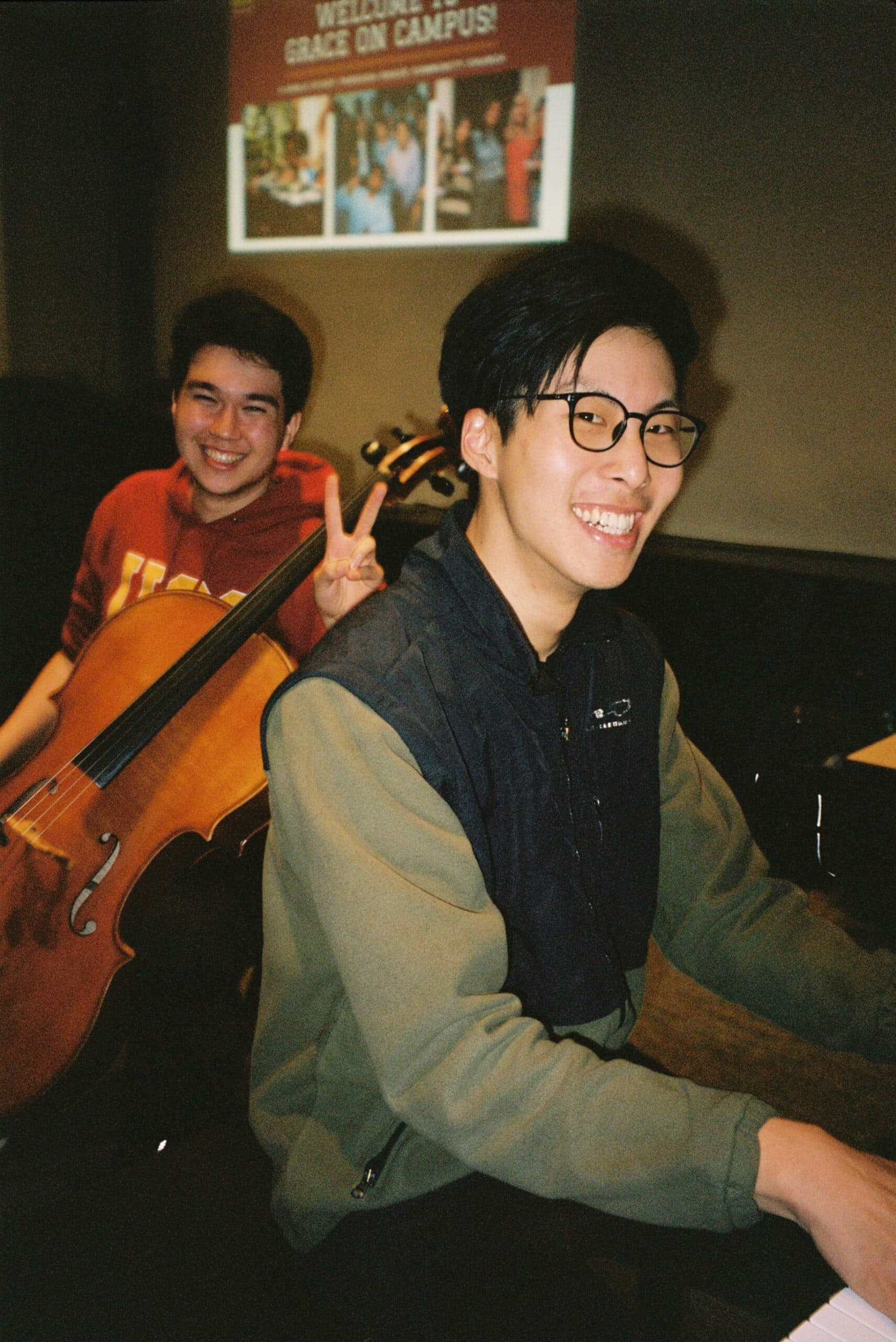 Students welcoming others to Grace on Campus with music and a welcome slide